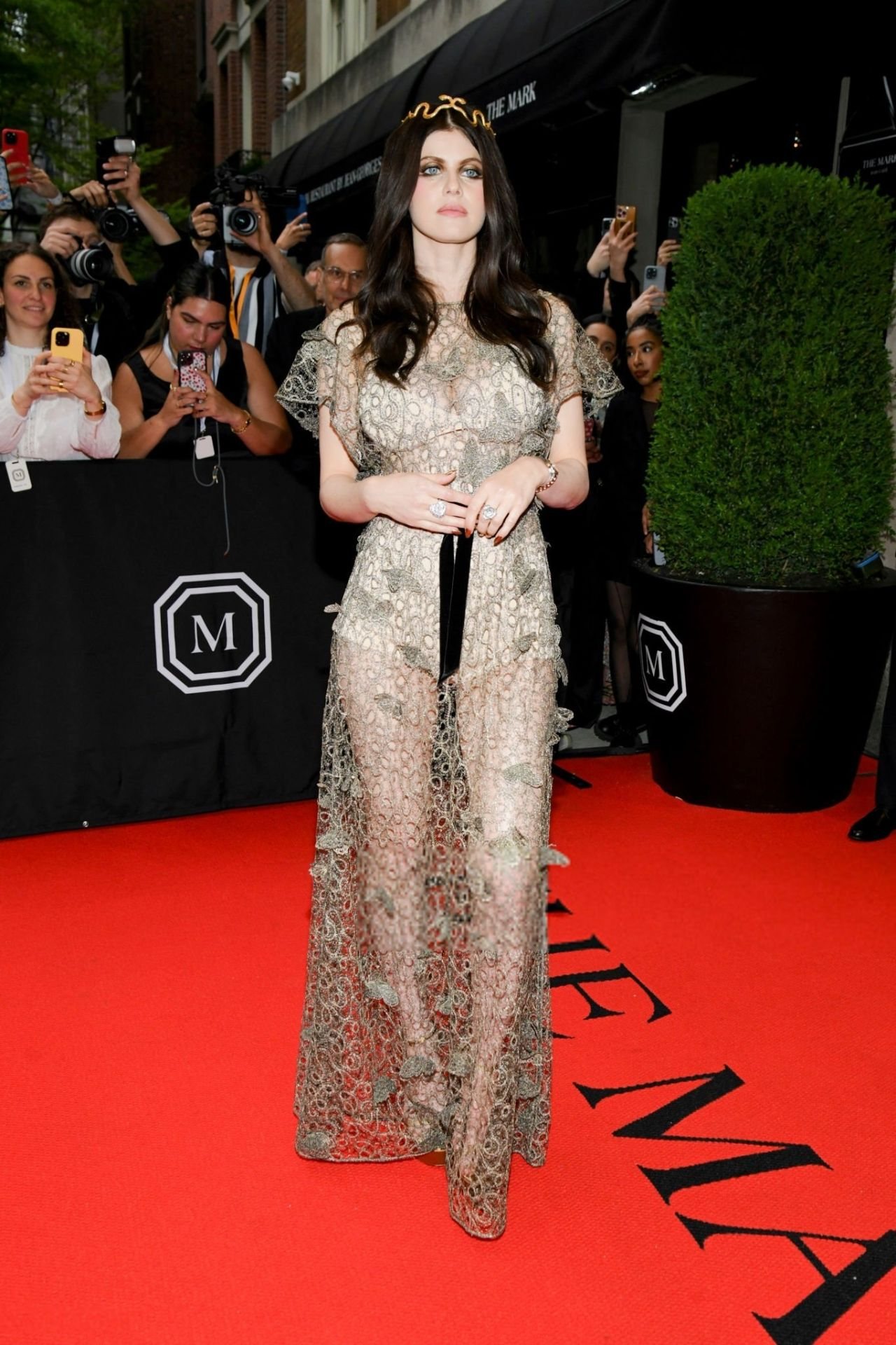 Alexandra Daddario on the red carpet in the gold lace Met Gala gown, snake in her hair