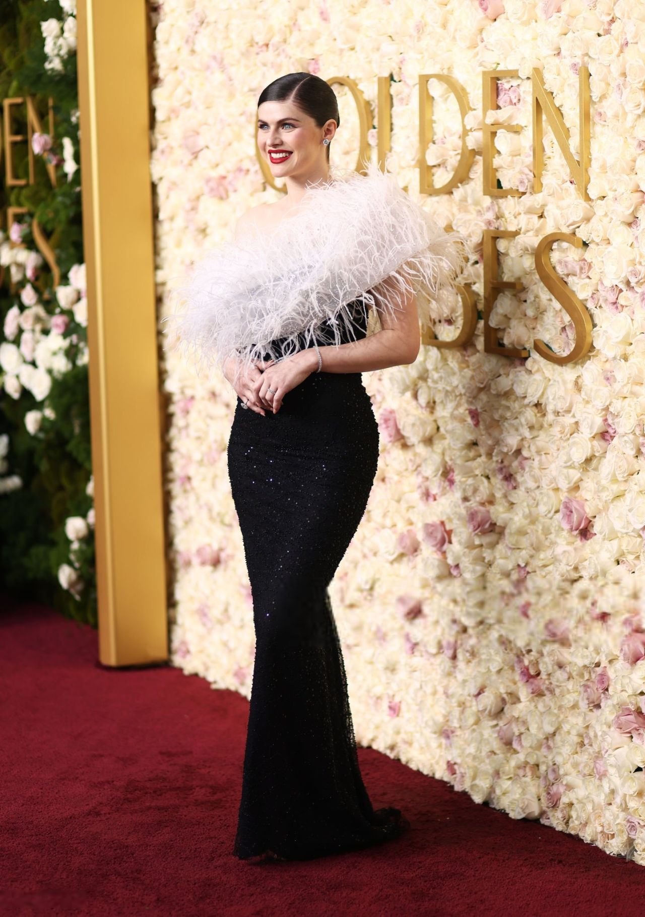 Alexandra Daddario full length in a black gown and feather stole at the Golden Globes
