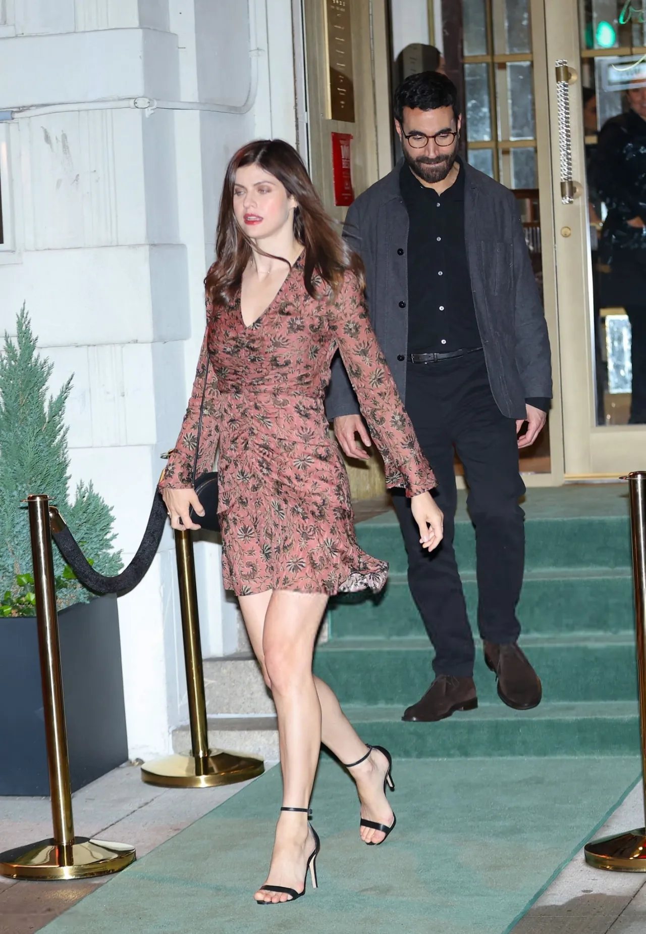 Alexandra Daddario in a floral mini dress leaving a doorway in Tribeca with a man in a suit