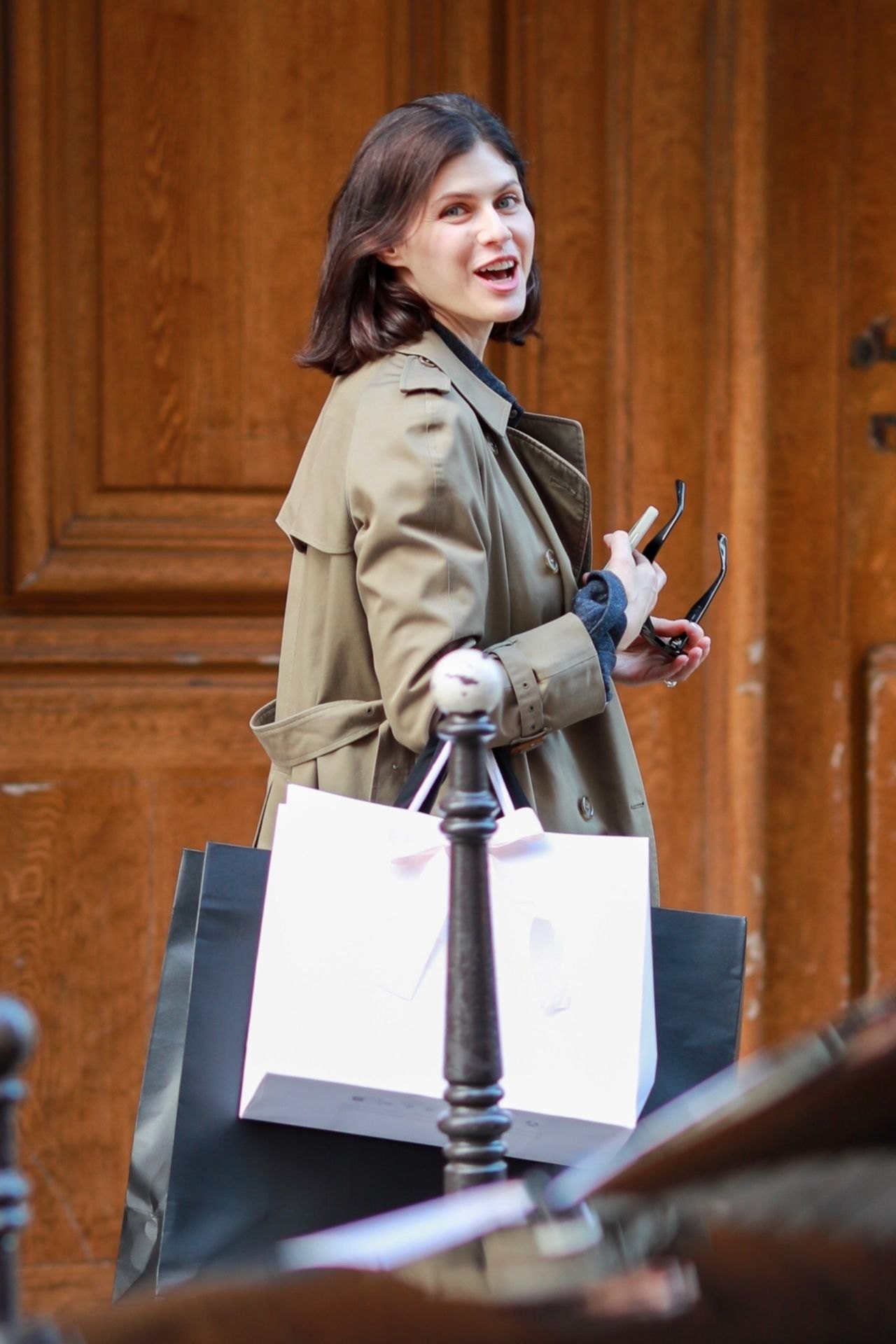 Alexandra Daddario in sunglasses and a trench on a Paris street