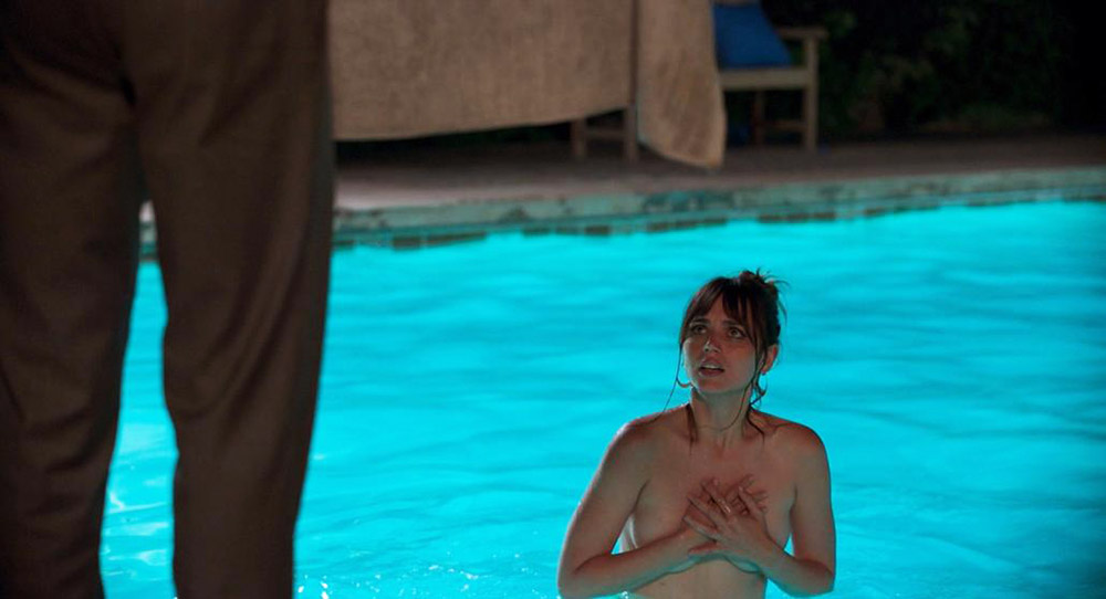 In the Night Clerk pool, hands on her chest, looking up
