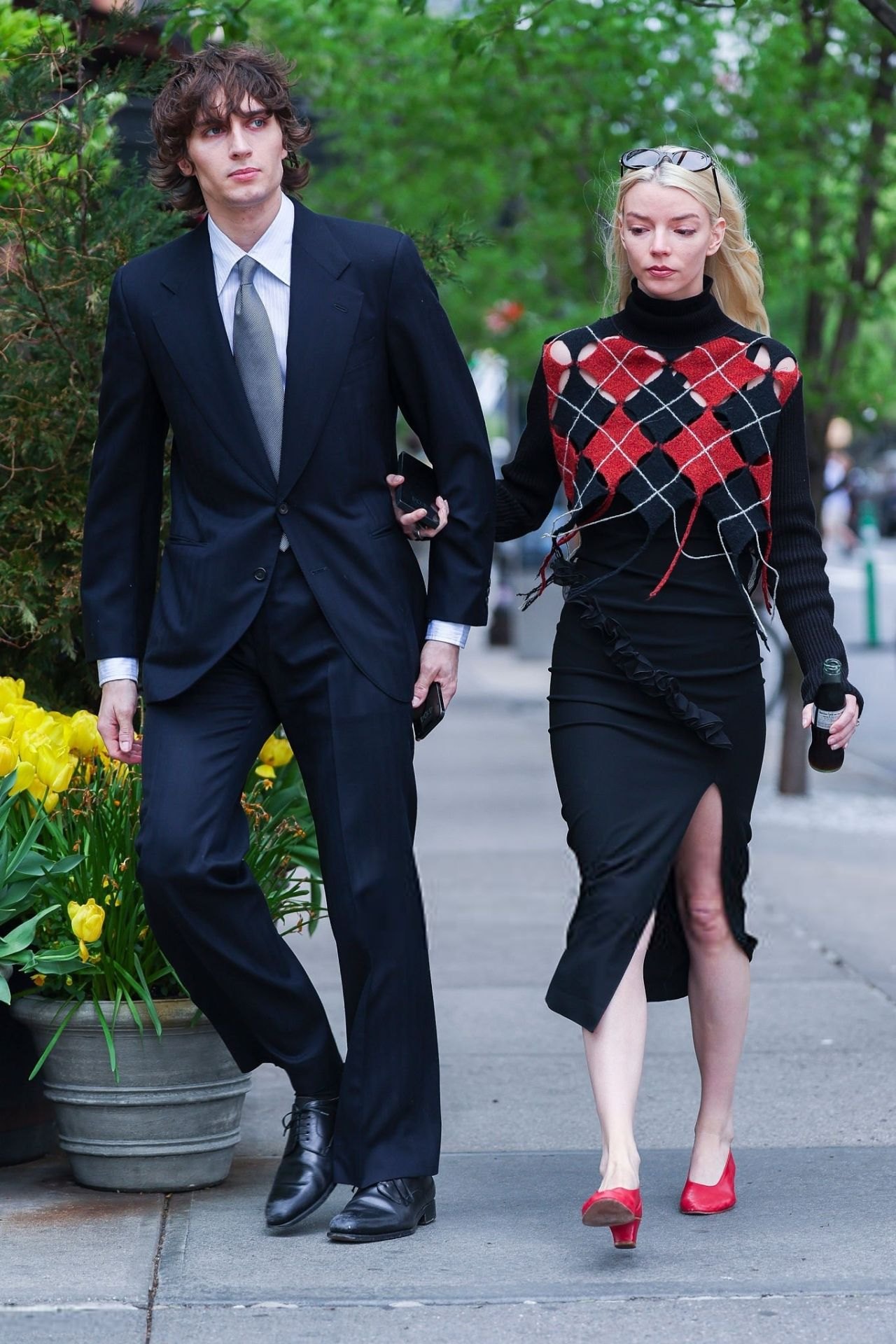 Anya Taylor-Joy in a red and black outfit with Malcolm McRae in New York, 2025