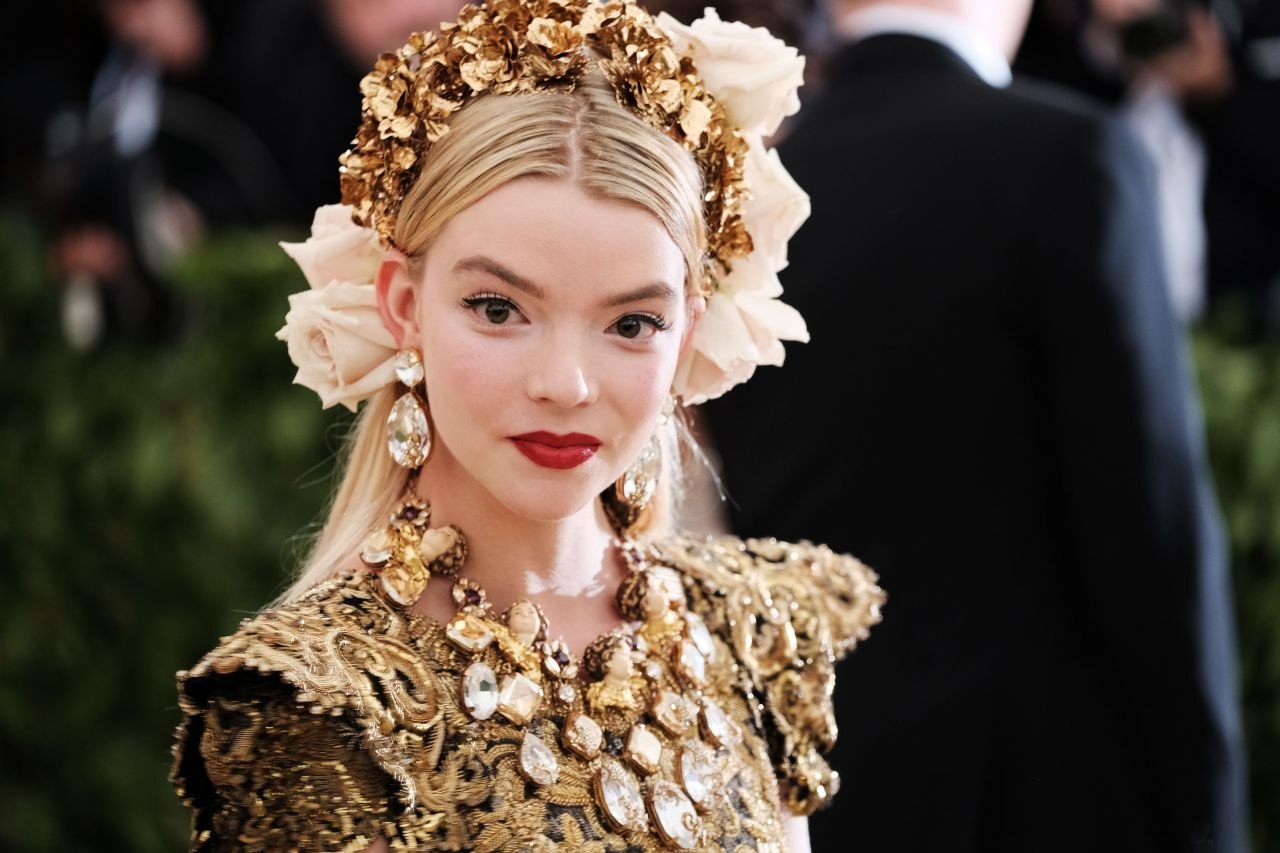 Anya Taylor-Joy in a gold gown and floral crown at the 2018 Met Gala