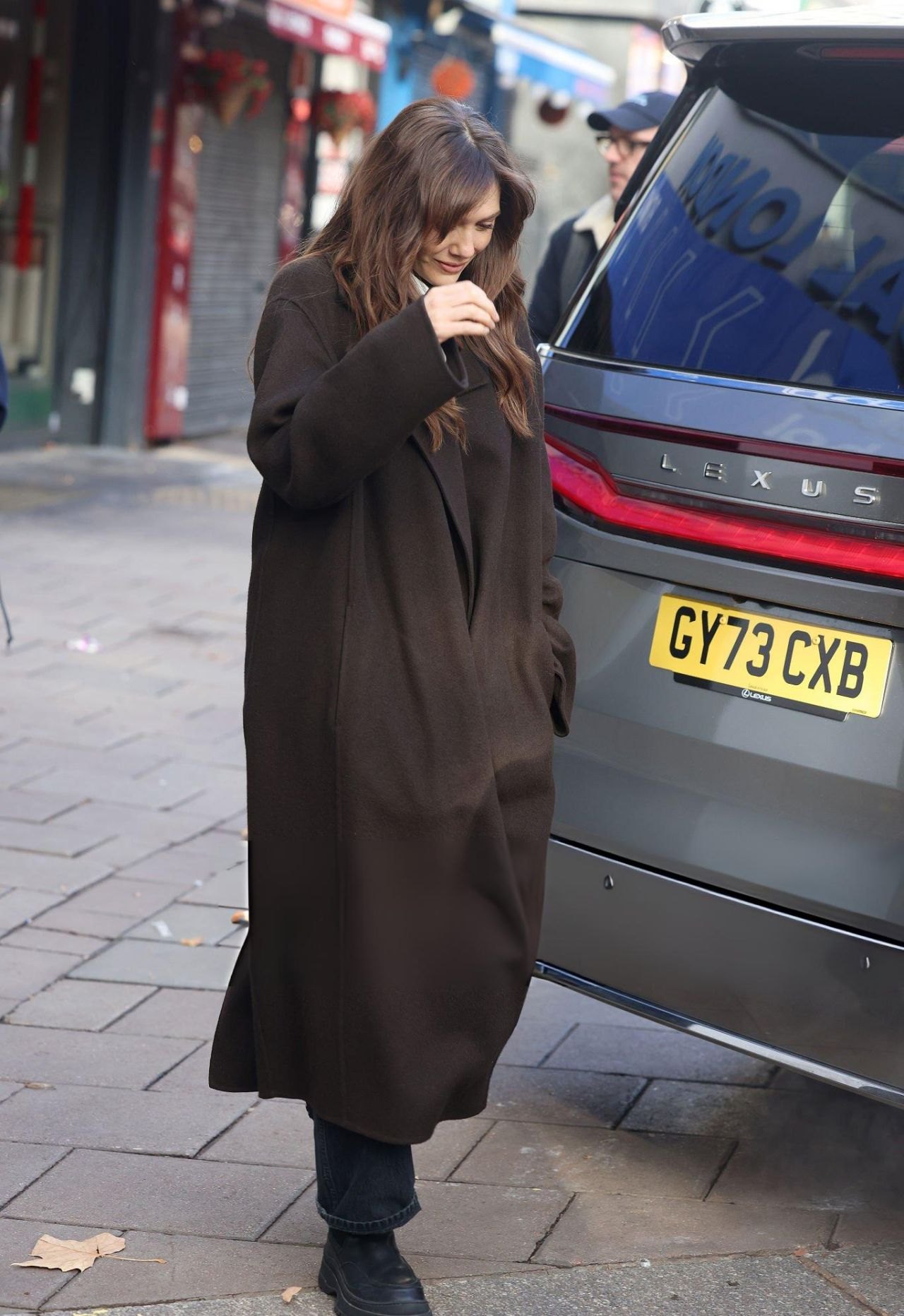 Elizabeth Olsen in a long brown coat leaving Heart Radio studios in London, 2025
