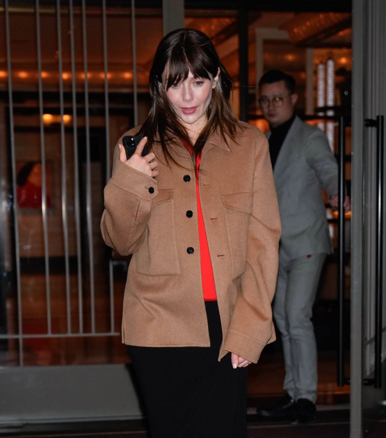 Elizabeth Olsen in a camel coat and orange top in New York City, 2025, photo 3