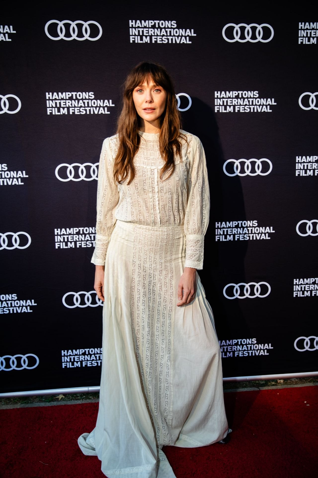 Elizabeth Olsen in a cream lace gown at the Hamptons Film Festival, 2025