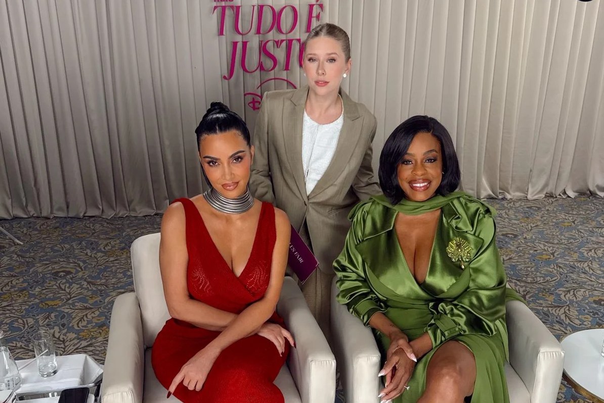 Kim Kardashian in a red plunging dress and Niecy Nash in green satin seated at an All's Fair press event in São Paulo, 2025