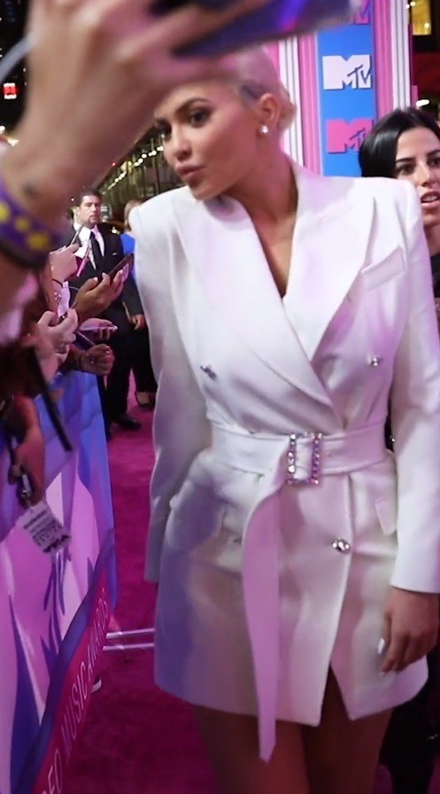 Kylie Jenner in a white blazer dress on the pink carpet at the 2018 MTV VMAs