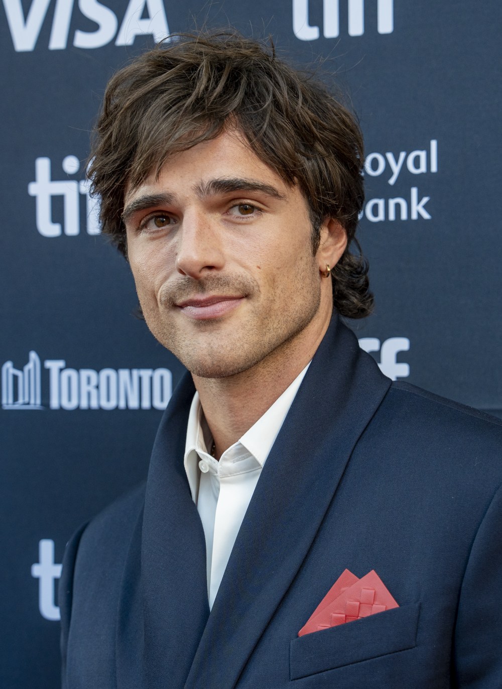 Jacob Elordi in a navy suit with a red pocket square at the 2025 Toronto International Film Festival