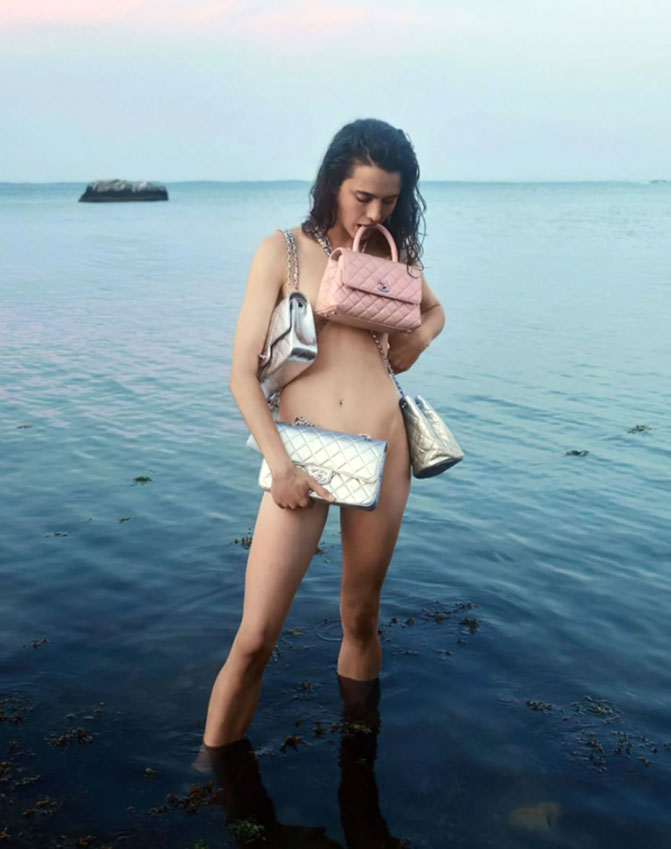 Margaret Qualley topless standing in the sea with a pink handbag
