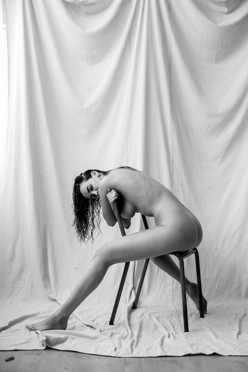 Sarah Stephens nude, folded over the chair, wet hair down, one leg stretched out